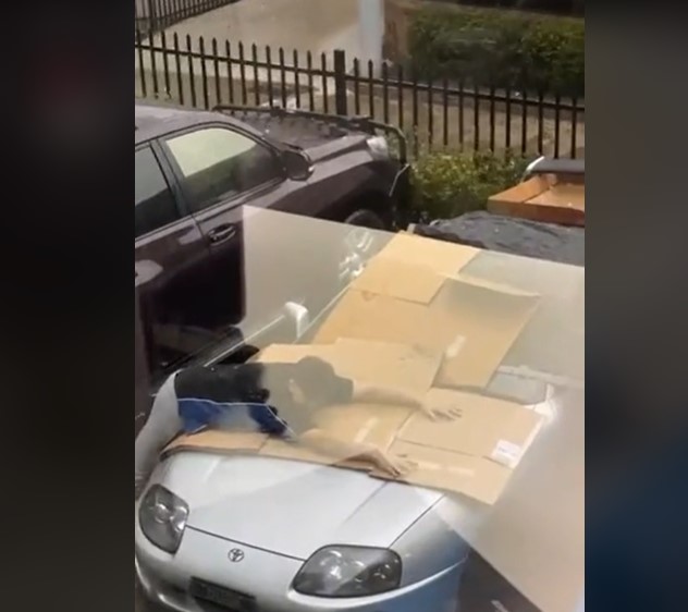 (Video) Hombre se enfrentó a fuerte aguacero para proteger su carro