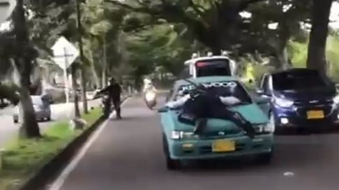 [Video] Conductor infractor lleva sobre el capot de su carro a un agente de tránsito