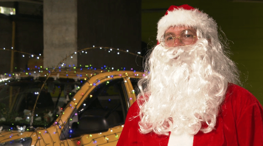 Papá Noel taxista lo lleva a su destino en su trineo amarillo